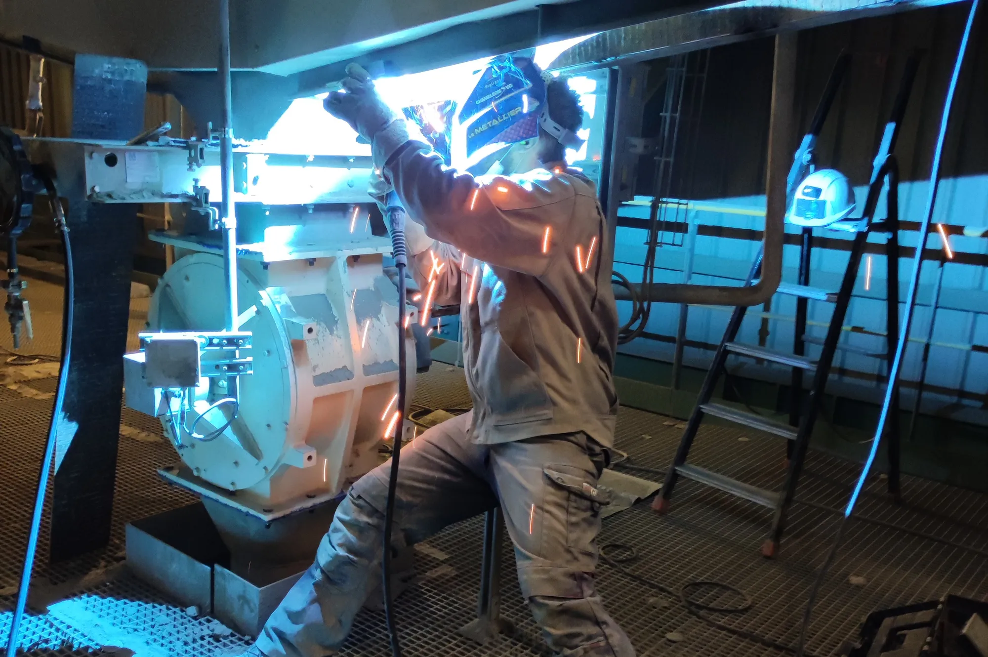 Personne soudant sur du matériel industriel
